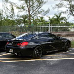 two black sports cars parked in a parking lot