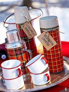 red and white coffee cups are on a silver tray with tags attached to the mugs