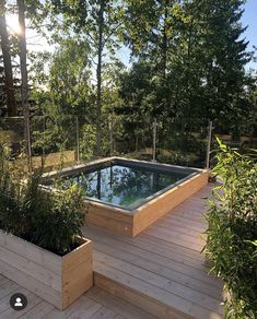 a wooden deck with an above ground pool surrounded by trees