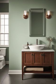 a bathroom with green walls and a white sink in it's center, next to a toilet