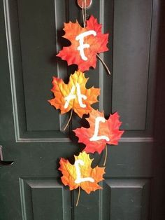 fall leaves are hanging on the front door with letters painted on them to spell out their name