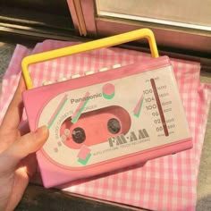 a person holding a pink toy car on top of a checkered table cloth with the words panasonic