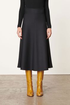 The mid-length black Boushra skirt is a wardrobe staple. Crafted in viscose-blend jersey, it offers a soft feel and elegant fall. Its trapeze cut and ruffles from the waist add movement and dimension to this minimalist piece. Wear it with a pair of high boots or ankle boots for a chic outfit. WHY WE LOVE IT Born in France to a Danish mother and an Italian father, Vanessa Bruno grew up in the fashion world. At just 25 years old, she launched her own brand and began her career as a fashion designe Evening Midi Skirt In Elastane, Knee-length Maxi Skirt For Workwear In Fall, Relaxed Viscose Skirt For Fall, Viscose Flared Skirt For Work, Workwear Viscose Flared Skirt, Ruffled Skirt Bottoms For Workwear In Fall, Fall Midi Skirt In Viscose, Black Viscose Skirt For Spring, Viscose Midi Skirt For Workwear