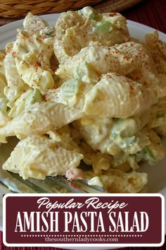 a white plate topped with pasta salad next to a basket filled with breadsticks