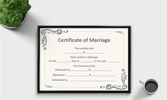 certificate of marriage sitting on top of a desk next to a cup of coffee and potted plant