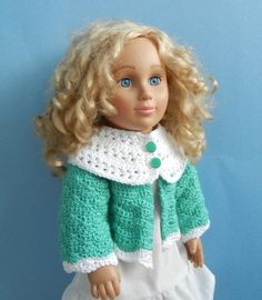 a doll with blonde hair wearing a green jacket and white dress on a blue background