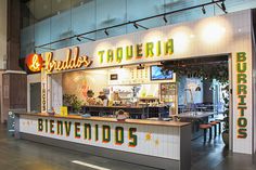 the inside of a mexican restaurant with neon signs on the front and back wall,