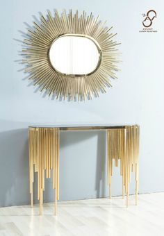 a mirror on the wall next to a console table with bamboo sticks in front of it