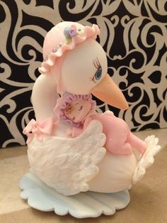 a figurine of a duck with a baby doll on it's back