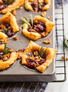 mini cranberry and pecan tarts on a baking tray with rosemary sprigs