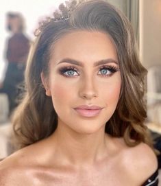 a woman with blue eyes wearing a tiara and looking at the camera while posing for a photo