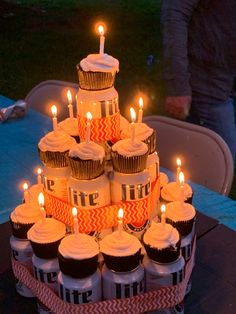 cupcakes are arranged in the shape of a cake with candles on each tier