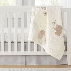 a baby crib with an elephant blanket on it