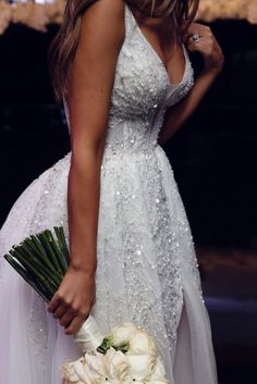 a woman in a wedding dress holding a bouquet