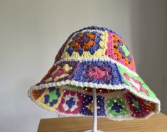 a multicolored crocheted hat sitting on top of a wooden table