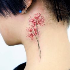 a woman with a tattoo on her neck and behind her ear is a red flower