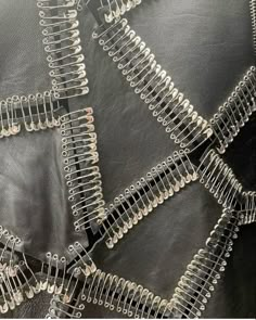 close up view of the back of a black leather jacket with metal zippers and rivets