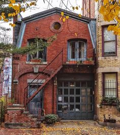 an old brick building with stairs leading up to the front door and second story window