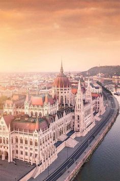 an aerial view of the hungarian parliament building in budapest, with river and city behind it