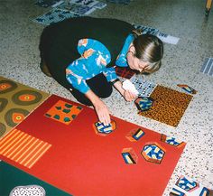 a woman kneeling down on the floor playing with tiles