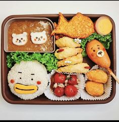 a bento box filled with rice, meat and veggies as well as other foods