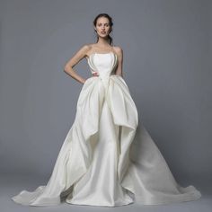 a woman in a white wedding dress posing for the camera with her hands on her hips