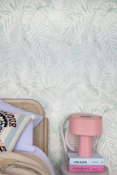 a bedroom with a bed, nightstand and wallpaper in pastel colors on the walls