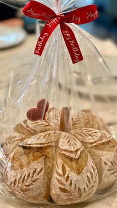 some cookies in a plastic bag on a table with a red ribbon around the top