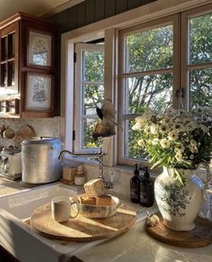 a kitchen sink sitting under a window filled with pots and pans on top of it