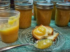 there is a plate with bread and jams on it next to some jars filled with jelly