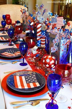 the table is set with red, white and blue decorations for an american themed celebration