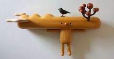 a wooden toy with two birds perched on it's head and one bird sitting on top of the other