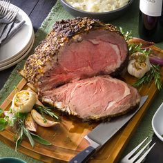 a large piece of meat sitting on top of a cutting board next to some vegetables