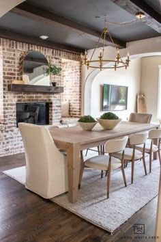 a dining room table and chairs in front of a fireplace