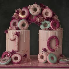 there are donuts on top of the cake that is decorated with flowers and ribbons