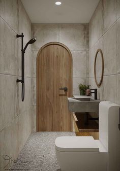 a bathroom with a toilet, sink and wooden door in the wall next to it