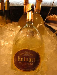 a bottle of rummart champagne sitting on top of ice next to bottles of wine