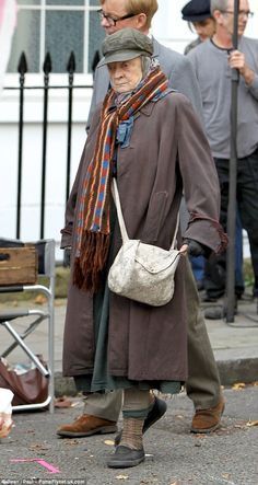 an old man walking down the street carrying a bag