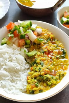 a bowl filled with rice and vegetables on top of a table next to other bowls