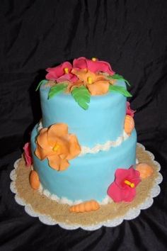 there is a blue cake with flowers on it