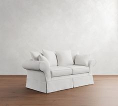 a white couch sitting on top of a wooden floor