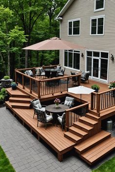 a deck with chairs and an umbrella in front of a house