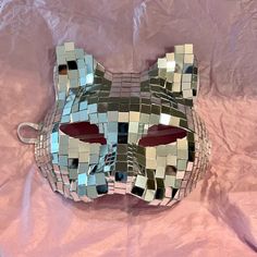 a mask made out of mirrored squares on a pink sheet