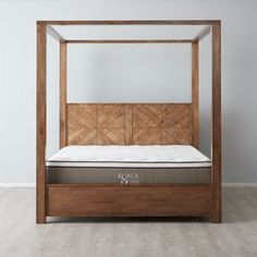 a bed with a wooden frame and mattress on it's side in an empty room