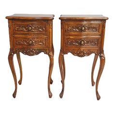 pair of carved wood nightstands with drawers on each side and one drawer at the top