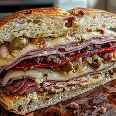 a close up of a sandwich with meat and vegetables on it, cut in half