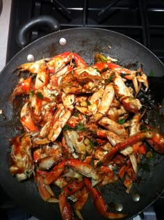 shrimp and peppers cooking in a wok on the stove