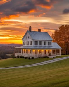 a large white house sitting on top of a lush green field