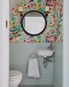 a bathroom with a sink, mirror and toilet in it's doorway way to another room