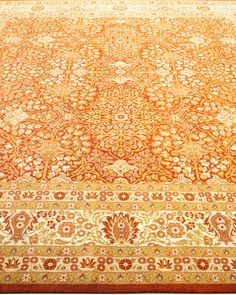 an orange and gold rug with floral designs